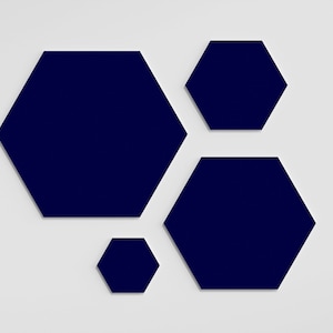 May include: A collection of four navy blue hexagon shapes of varying sizes against a white background. The shapes are arranged in a visually appealing, asymmetrical composition, creating a modern design.