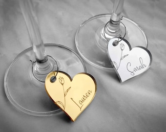 Heart Shape Wine Glass Name Tag Made From Reflective Mirrored Acrylic With Guest Names And Floral Decoration.