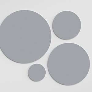 May include: Four gray circles of different sizes on a white background. The circles are arranged in a cluster.