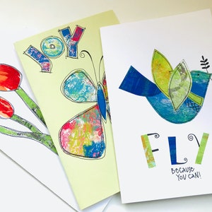 Op de afbeelding: Drie wenskaarten met kleurrijke ontwerpen. De eerste kaart heeft een vlinder met een geel, blauw en roze ontwerp en het woord "JOY" in blauwe en rode letters. De tweede kaart heeft een blauwe vogel met groene vleugels en het woord "FLY" in groene en gele letters. De derde kaart heeft een boeket rode tulpen met groene stelen.