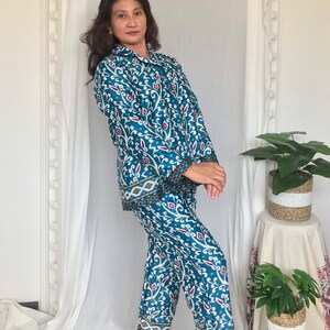 May include: A blue and white patterned pajama set with a long-sleeved shirt and pants. The shirt has a collar and button closure. The pants have a straight leg.