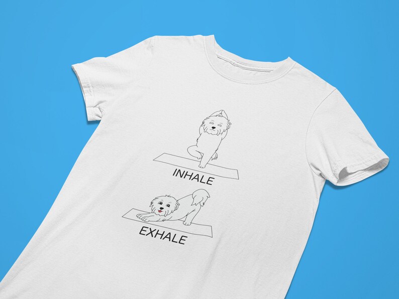 May include: White t-shirt with a black line drawing of a dog doing yoga poses. The text "INHALE" and "EXHALE" are printed on the shirt.