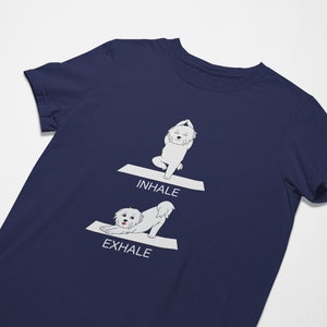 May include: A navy blue t-shirt with a white graphic of a dog doing yoga poses. The text "INHALE" and "EXHALE" are printed on the shirt.
