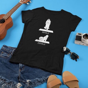 May include: Black t-shirt with a white dog doing yoga poses. The text "INHALE" and "EXHALE" are printed on the shirt.