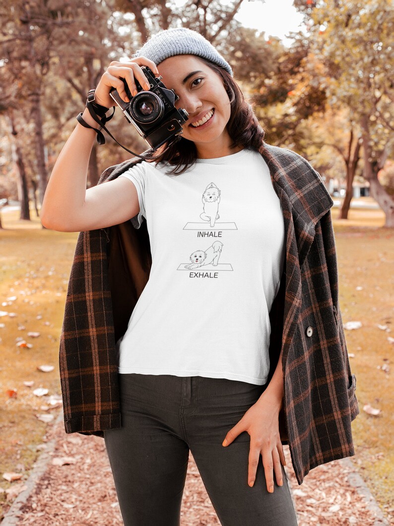 May include: White t-shirt with a black line drawing of a dog doing yoga poses. The text "INHALE" and "EXHALE" are printed on the shirt.