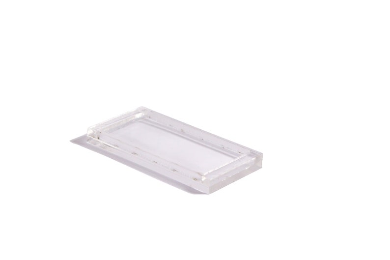 May include: A clear plastic rectangular tray with a raised edge.