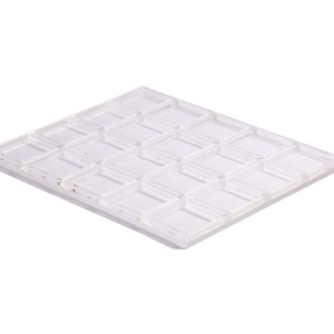 May include: A clear plastic mold with 24 square compartments. The mold is designed for making chocolate or other treats.
