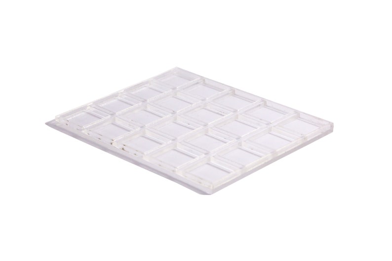 May include: A clear plastic mold with 24 square compartments. The mold is designed for making chocolate or other treats.