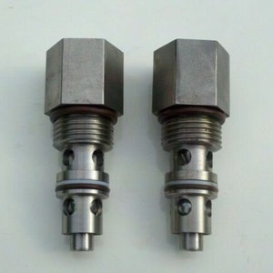 May include: Two silver metal valve stems with hexagonal heads. The stems have multiple grooves and rings.