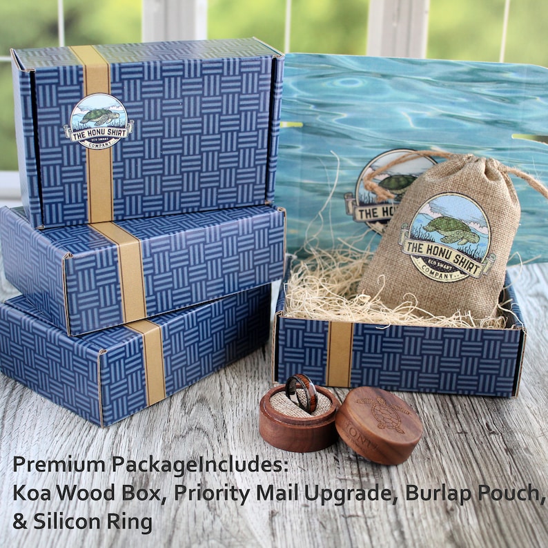 May include: A blue and gold patterned box with a smaller wooden box inside. The wooden box contains a ring. The larger box has a logo that says "The Honu Shirt Company".