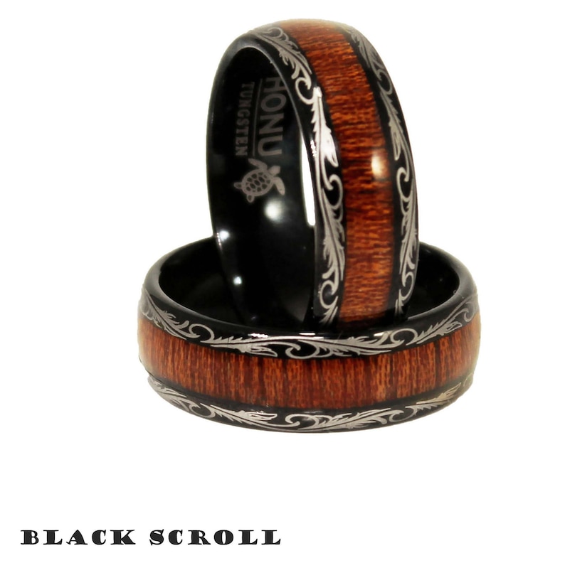 May include: Two black tungsten rings with a brown wood inlay and a silver scroll design. The top ring has the word "HONU" and "TUNGSTEN" engraved on the inside.
