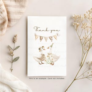 May include: A white card with the text "Thank you" in brown script. Two white ducks with brown hats and a string of brown and white checkered flags are illustrated on the card.