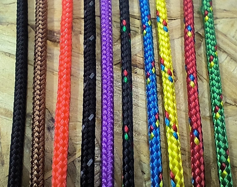 K&ouml;nnte beinhalten: Sortiment an bunten geflochtenen Seilen mit verschiedenen Mustern. Die Seile sind in einer Reihe angeordnet und alle gleich lang.