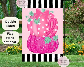 May include: Double-sided pink and white garden flag featuring a pink pumpkin with white polka dots and a pink ribbon. The pumpkin sits atop a smaller pink pumpkin with a floral design. The flag has a black and white striped border.
