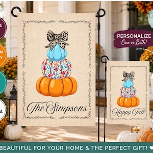 May include: Two rectangular garden flags with a burlap-textured background and a black vine border. The flags feature a stack of three pumpkins topped with a leopard print bow. One flag displays the text The Simpsons, the other says Happy Fall.