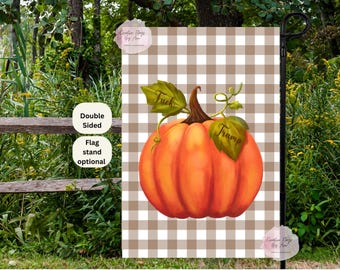 May include: A double-sided garden flag featuring a large orange pumpkin with green leaves. The pumpkin has the words "Fuck" and "Trump" on the leaves. The background is a brown and white checkered pattern.
