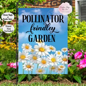May include: A garden flag with a blue sky background and white daisies. The text "POLLINATOR frindley GARDEN" is printed in black on the flag.