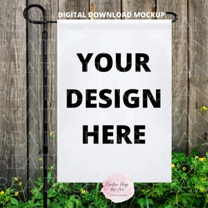 May include: White garden flag mockup with the text "YOUR DESIGN HERE" printed in black. The flag is hanging on a black metal pole against a wooden fence background.