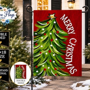 May include: A rectangular garden flag featuring a painted green Christmas tree with a yellow star topper, decorated with red and white circular ornaments against a solid red background. The text Merry Christmas is printed in white vertical lettering.