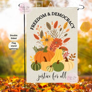 May include: A double-sided garden flag with a fall theme. The flag features a bouquet of flowers and pumpkins in shades of orange, yellow, and green. The words "Freedom & Democracy" and "justice for all" are printed on the flag.