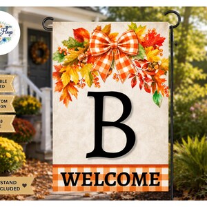 May include: A rectangular garden flag featuring a large black letter B, an orange and white checkered bow, and autumn leaves. The bottom border has an orange and white checkered pattern with the word WELCOME in black. It measures 12x18 inches.