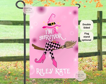 Könnte beinhalten: Rosa Gartenflagge mit Hexen-Thema, mit dem Text "I'M SURVIVOR" und "RILEY KATE". Das Design umfasst einen Hexenhut, einen Besen und Beine mit karierten Hosen. Die Flagge ist doppelseitig und der Fahnenständer ist optional.