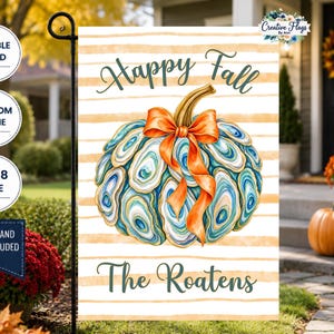 May include: A rectangular garden flag featuring a pumpkin made of blue and white oyster shells with an orange bow. The background has horizontal tan stripes. The text reads Happy Fall and The Roatens. The flag is 12x18 inches in size.