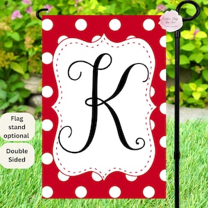 May include: A red and white polka dot garden flag with a white frame and the letter "K" in black script. The flag is double-sided and has a flag stand.