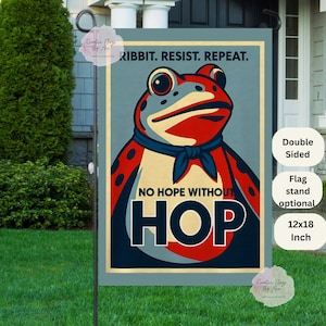 May include: A double-sided garden flag featuring a stylized frog illustration with the text "RIBBIT. RESIST. REPEAT." and "NO HOPE WITHOUT HOP." The flag measures 12x18 inches.