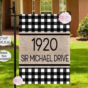 May include: A black and white buffalo check house flag with the address "1920 SIR MICHAEL DRIVE" in black lettering. The flag is 12" x 16" and made of vinyl. The stand is not included.