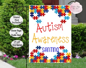 May include: A white 12x16 inch vinyl banner with a blue, red, and yellow puzzle piece design. The banner reads "Autism Awareness" in red and yellow lettering with the name "SANTINO" in blue lettering below.