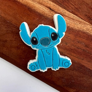 May include: A blue and white 3D printed cookie cutter shaped like Stitch from the Disney movie Lilo & Stitch.