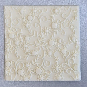 Op de afbeelding: Witte siliconen mal met een reliëf ontwerp van delicate witte bloemen en wijnstokken.