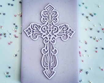 May include: A purple silicone mold with a detailed, white, decorative cross design.