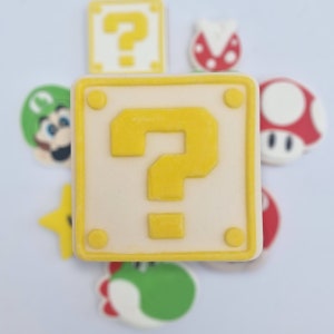 May include: A collection of colourful cartoon character decorations. Features a large yellow question mark block, a red and white mushroom, a green Yoshi, a yellow star, and a green Luigi.