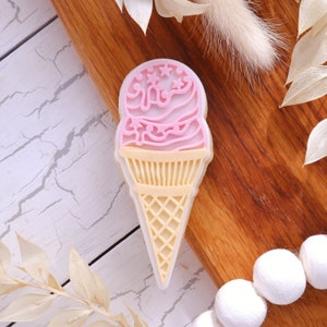 Op de afbeelding: Een roze en witte ijshoorn koekjesuitsteker met een wafelkegel ontwerp.
