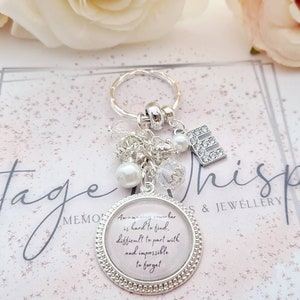 May include: A silver keychain with a charm that reads "Amazing coworkers are hard to find, difficult to part with and impossible to forget". The charm is surrounded by small silver beads and a pearl.