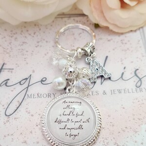 May include: Silver keychain with a charm that reads "An amazing colleague is hard to find, difficult to part with and impossible to forget". The keychain also has a silver letter A charm and other decorative charms.