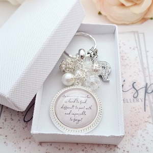 May include: A silver keychain with a charm that reads "An amazing coworker is hard to find, difficult to part with and impossible to forget". The charm is surrounded by small silver beads and crystals.