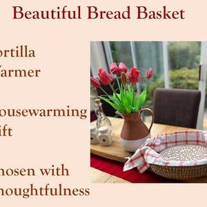 Puede incluir: Una cesta de pan tejida redonda forrada con un pa&ntilde;o blanco con un patr&oacute;n de cuadr&iacute;cula roja. El texto en la imagen dice Beautiful Bread Basket, Tortilla Warmer, Housewarming Gift y Chosen with Thoughtfulness en color rojo oscuro.
