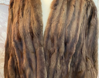 Vintage faux mink cape. Measures approximate medium size. Lovely soft fur. Clean satin lining fits up to a size medium. 2 hook and eyes