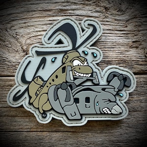 May include: A gray and brown cartoon patch of a helicopter with a distressed look, with the word "S**T**" in a stylized font above it.