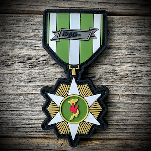 May include: A green and white striped ribbon with a silver banner that reads "1950-" hangs above a green star with a red and green map inside. The star is surrounded by a ring of gold rays.