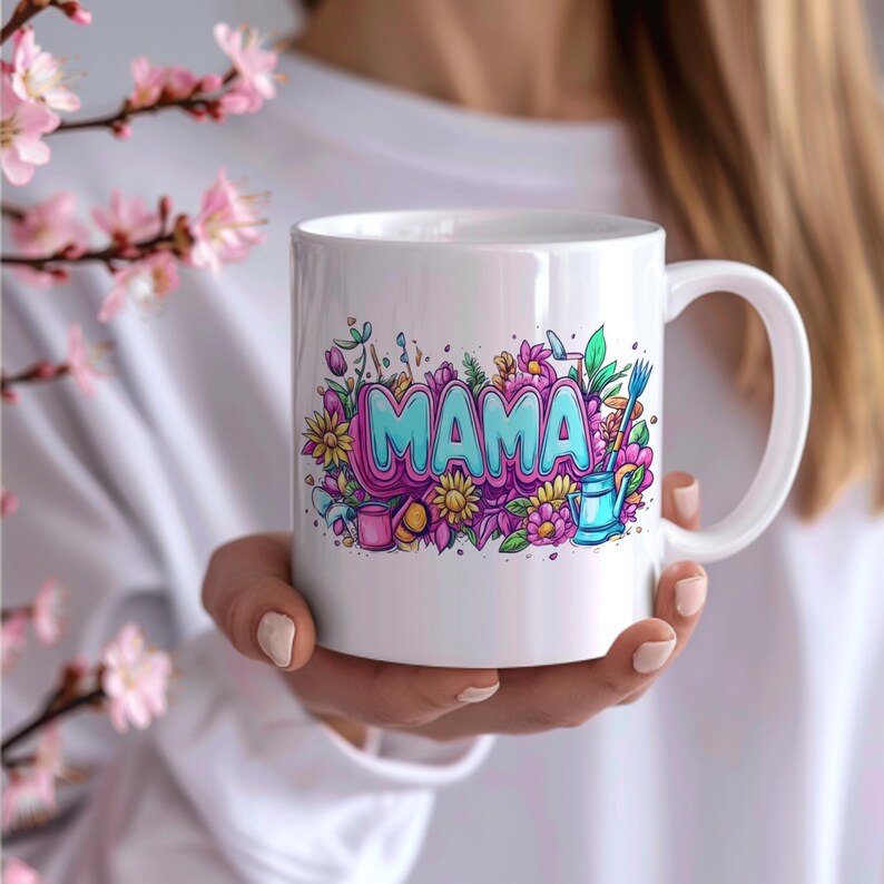 May include: White ceramic coffee mug with a colorful illustration of flowers and the word "MAMA" in blue and pink letters.
