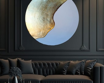 May include: A black velvet sofa with gold trim and tufted upholstery sits in front of a black wall with a large circular abstract painting featuring gold and blue paint.