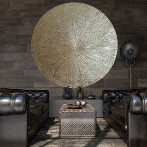 May include: Two black leather sofas with tufted upholstery and a metal coffee table with a distressed finish. A large circular wall art piece with a metallic finish hangs above the sofas.