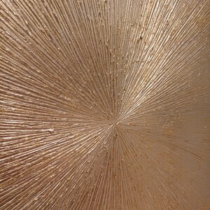 May include: A close-up of a textured, metallic gold surface with a radial pattern. The surface is smooth and shiny, with a subtle shimmer.