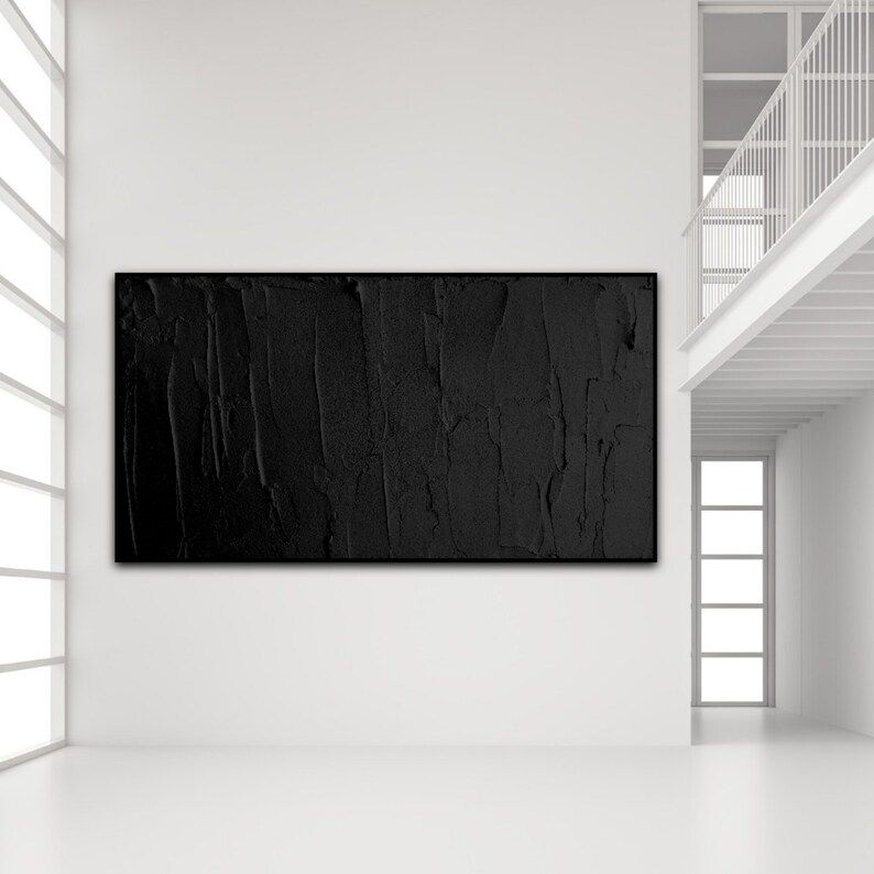 Puede incluir: Una pintura abstracta en blanco y negro con una superficie texturizada cuelga de una pared blanca en un interior moderno.