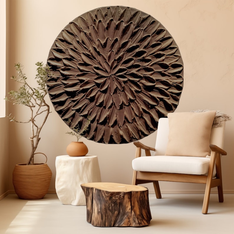 May include: A large, round wall decor with a brown, textured, flower-like design. The decor is hanging on a light beige wall.