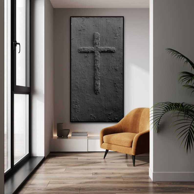 Peut inclure: Une peinture abstraite en noir et blanc d'une croix sur un fond textur&eacute;. La peinture est accroch&eacute;e &agrave; un mur dans un salon moderne avec un fauteuil marron et une plante.